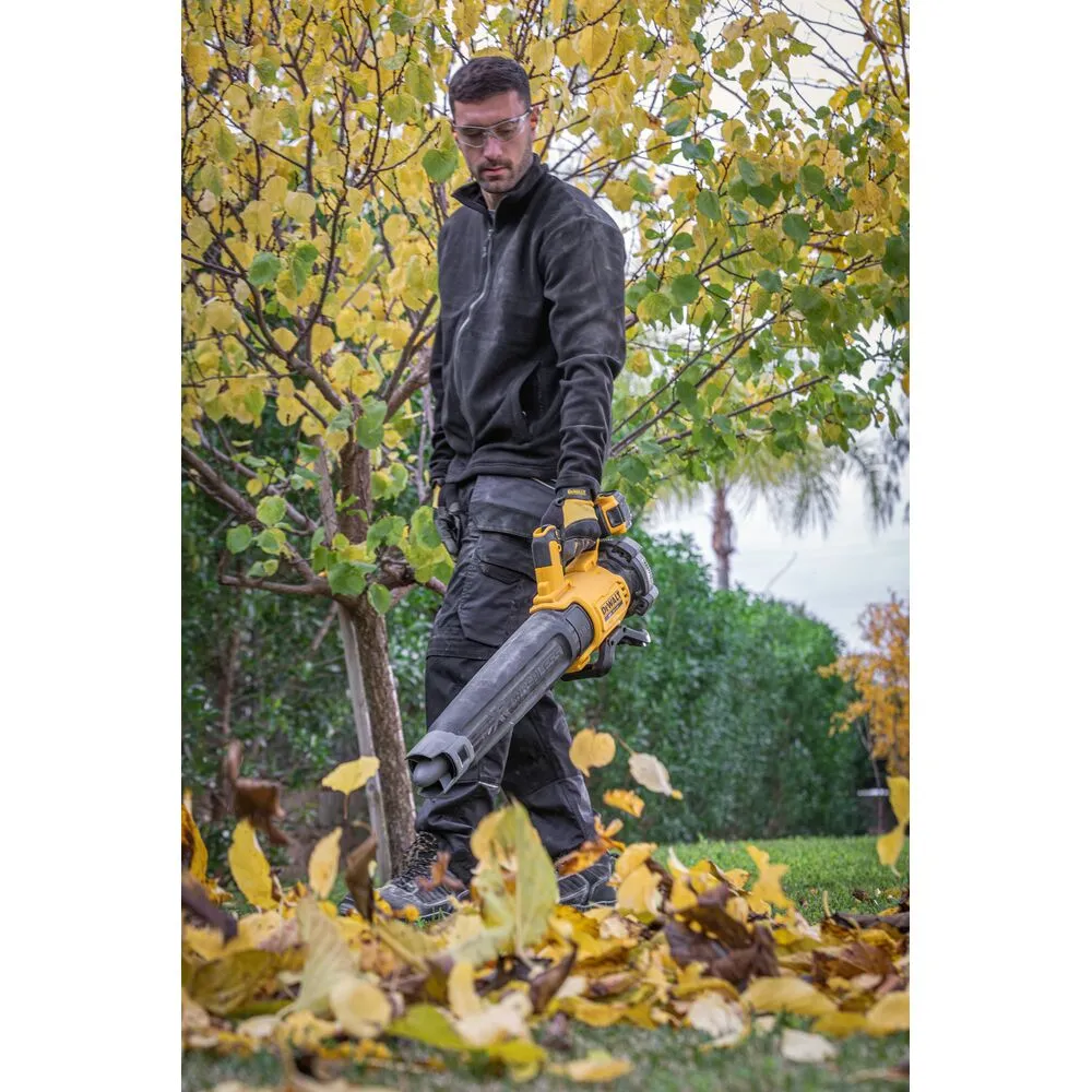 Pildil on kujutatud DeWalt akutoitega lehepuhurit DCMBL562P1, mida hoiab käes inimene tööriistaga kindad käes.