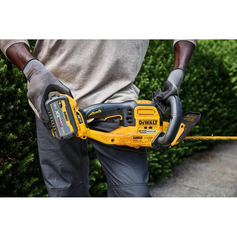 Pildil on näha DeWalt akutoitega hekipügajat, mida hoiab käes inimene.
