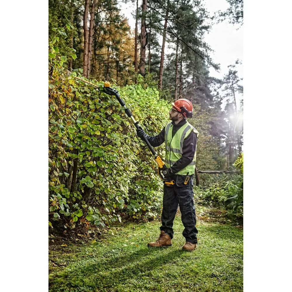 Pildil on mees, kes kasutab DeWalt akuga kõrghekilõikurit DCMPH566N, ilma aku ja laadijata, et lõigata hekki.