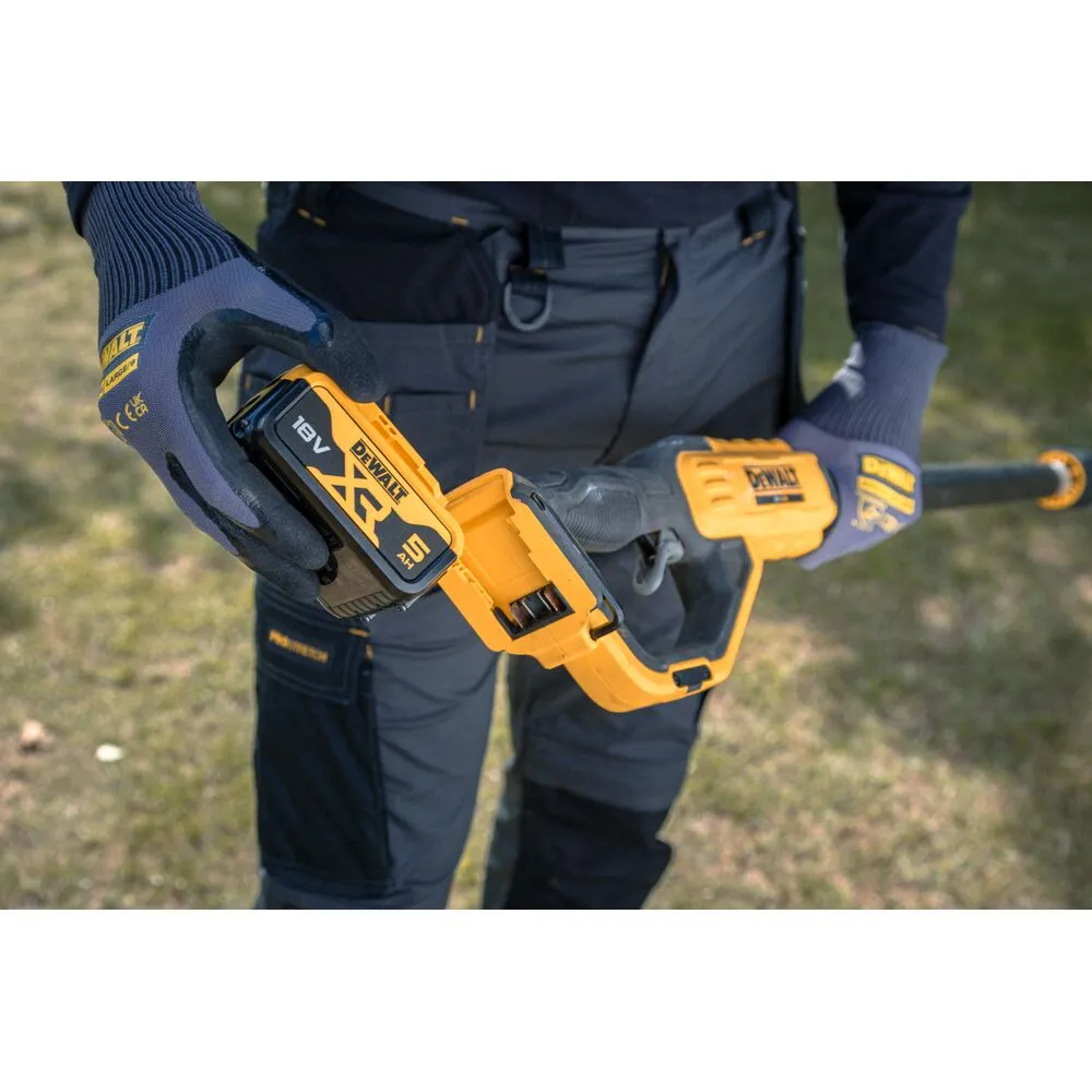 Pildil näeb mees DeWalt akuga teleskoop-oksalõikurit, millele ta paigaldab akut.