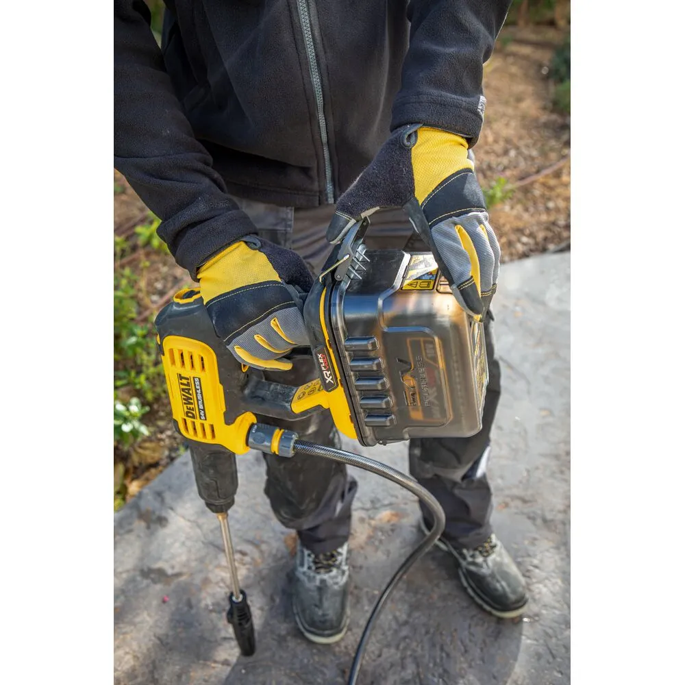 Pildil on näha DeWalt akusurvepesur DCMPW1000N, millel on küljes aku ja inimene hoiab seda käes.