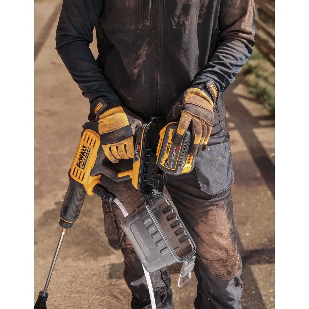 Pildil on DeWalt akusurvepesur DCMPW1000N, mida hoiab mustades tööriietes ja kinnastes inimene, kes valmistub seda kasutama.