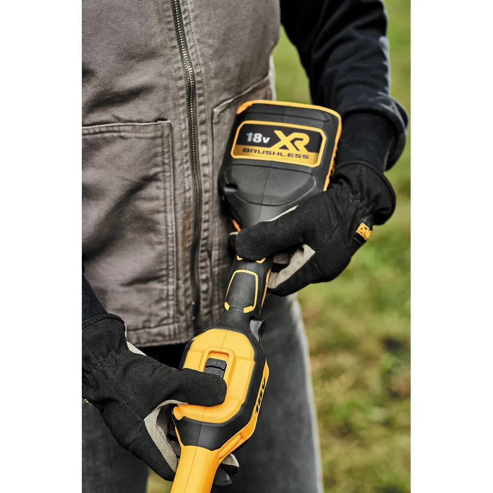 Pildil on DeWalt akutrimmer DCMST561P1, mida kasutab inimene.