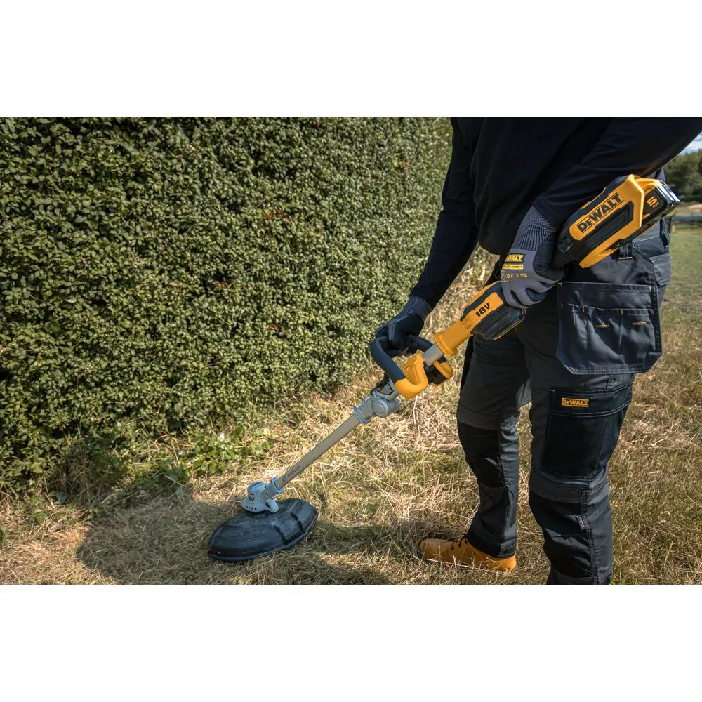 Pildil on näha, kuidas inimene hoiab DeWalt akutrimmerit koos akuga.