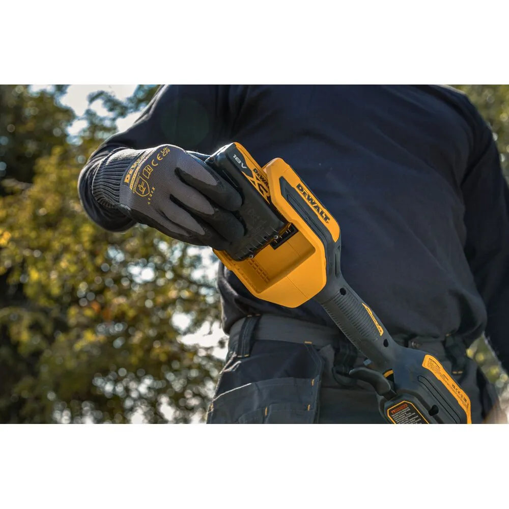 Pildil on näha DeWalt akutrimmer DCMST561P1, mida kasutaja käes hoiab.