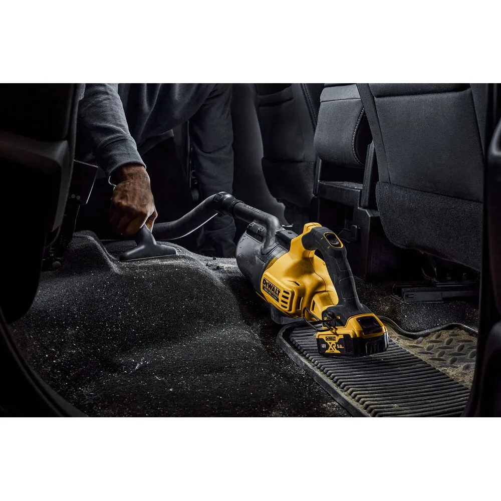 Pildil on näha DeWalt akutolmuimeja DCV501LN koos vooliku ja otsikuga, mida kasutatakse auto interjööri puhastamiseks.