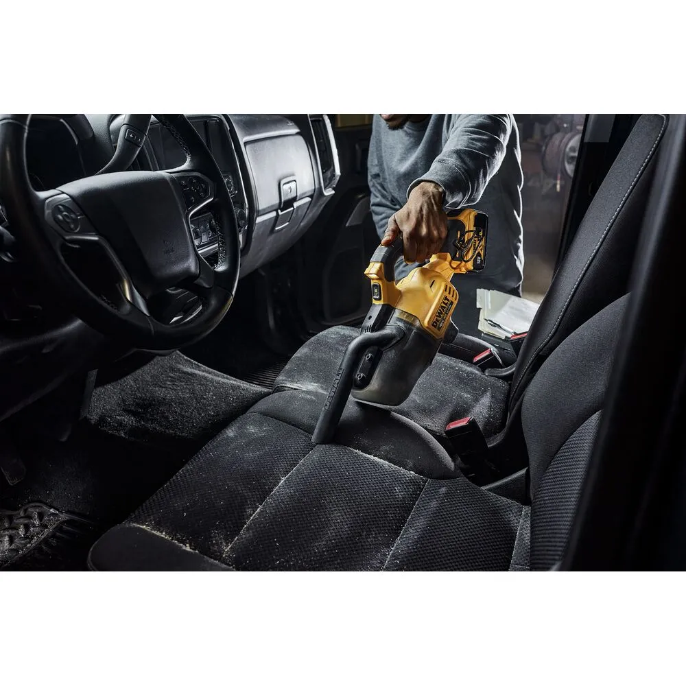 Pildil on inimene, kes kasutab DeWalt akutolmuimejat, et puhastada määrdunud autot.