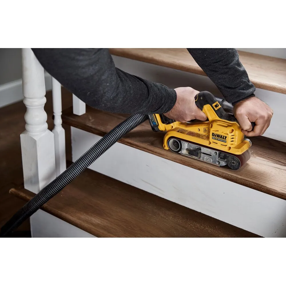 Pildil on DeWalt akulintlihvija DCW220N, mida kasutatakse puidust trepiastme lihvimiseks, samal ajal kui tolm...