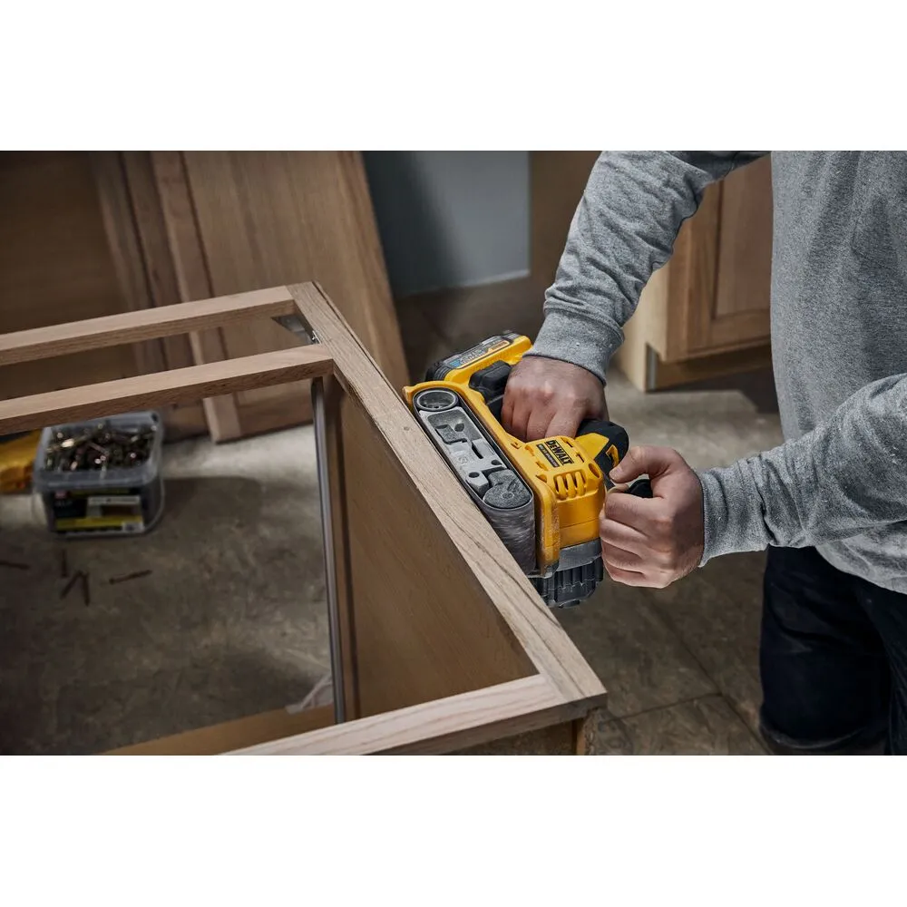 Pildil on näha DeWalt akulintlihvija DCW220N, mida mees kasutab puidust detaili lihvimiseks.