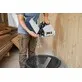 Pildil on mees, kes tühjendab Festool tolmukogumiskotti SB/2-TSC/HKC, suunates saepuru ämbrisse.