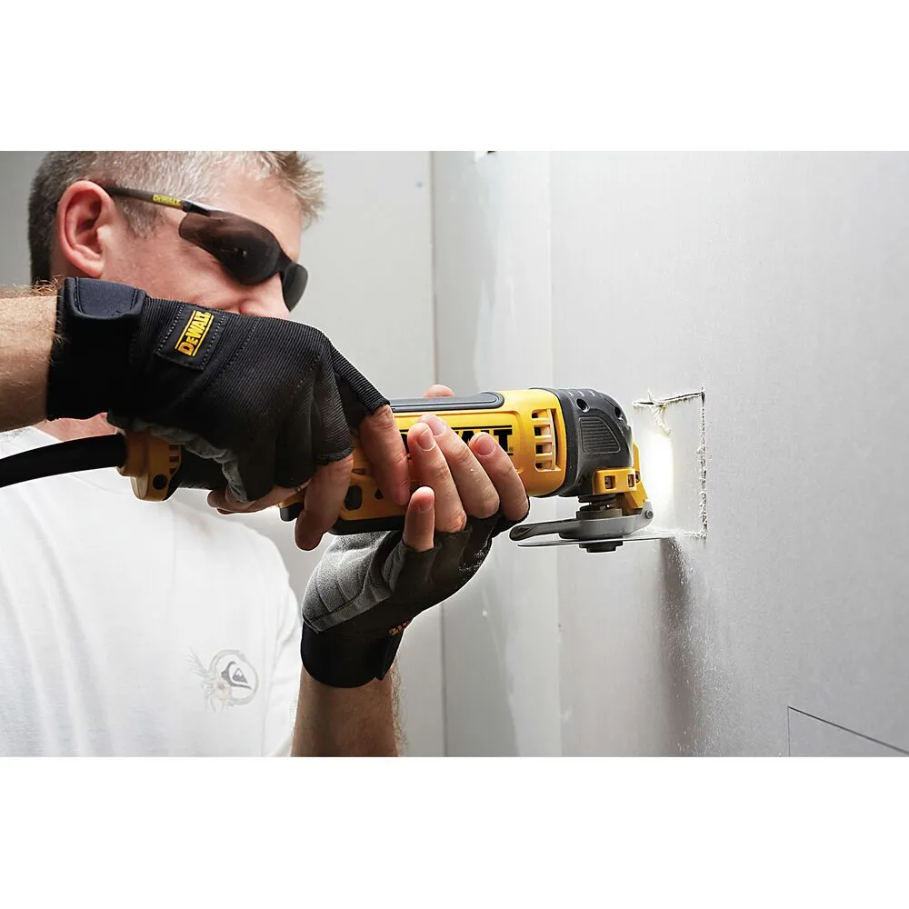 Pildil on näha mees, kes kasutab DeWalt universaallõikuri teraga 100 mm sisselõiget seinas.