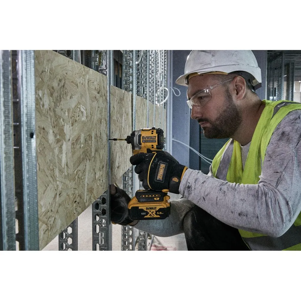 Pildil on töömees, kes kasutab kollast DeWalt löökotsakute komplekti FLEXTORQ 31-osaline, paigaldades puitlaastplaati...