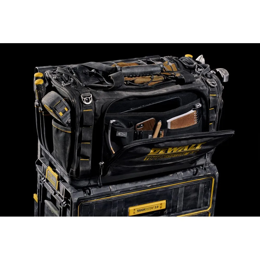 Pildil on must DeWalt tööriistakott TOUGHSYSTEM 2.0, mis on asetatud samanimelisele mustale tööriistakastile.