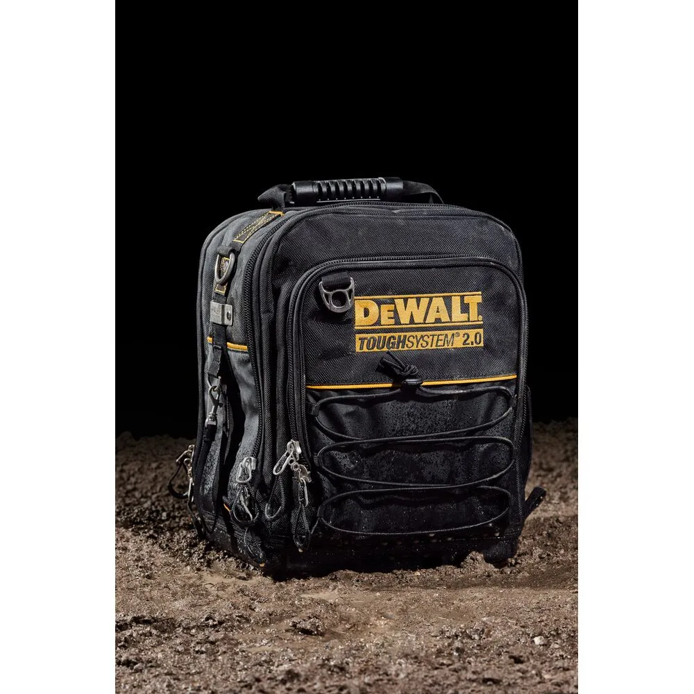 Pildil on näha must tööriistakott, millel on kollane Dewalt Toughsystem 2.0 logo, mis seisab mudasel pinnal.