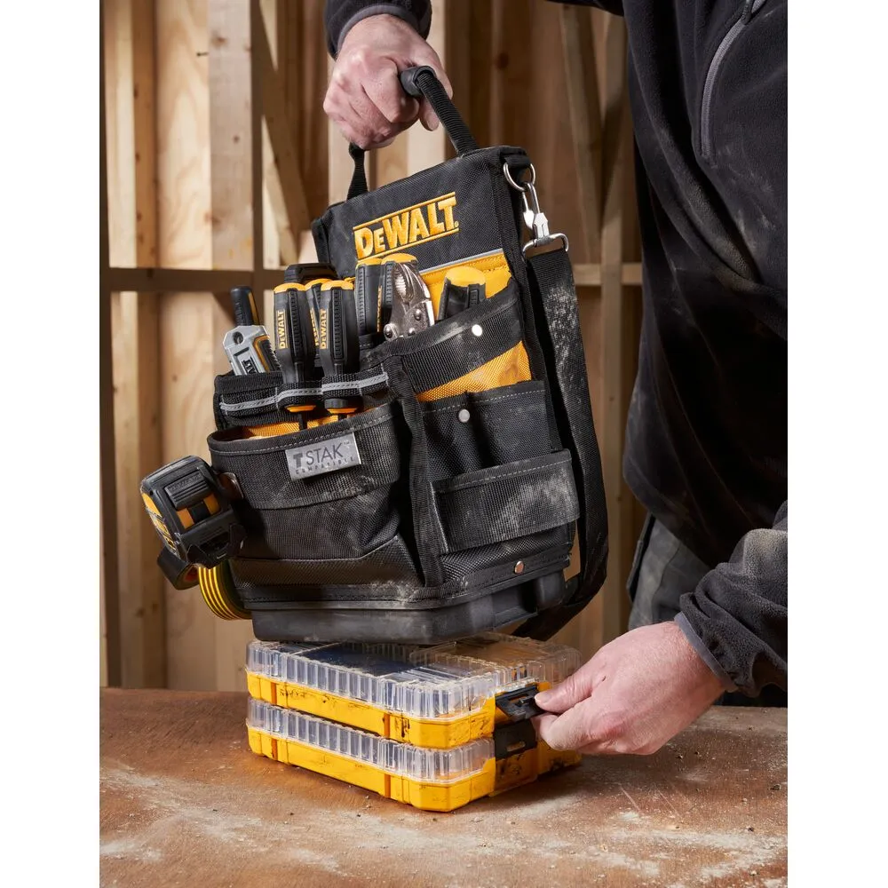 Pildil on DeWalt TSTAK avatud tööriistakott täis tööriistu, mis on asetatud kollastele karpidele.