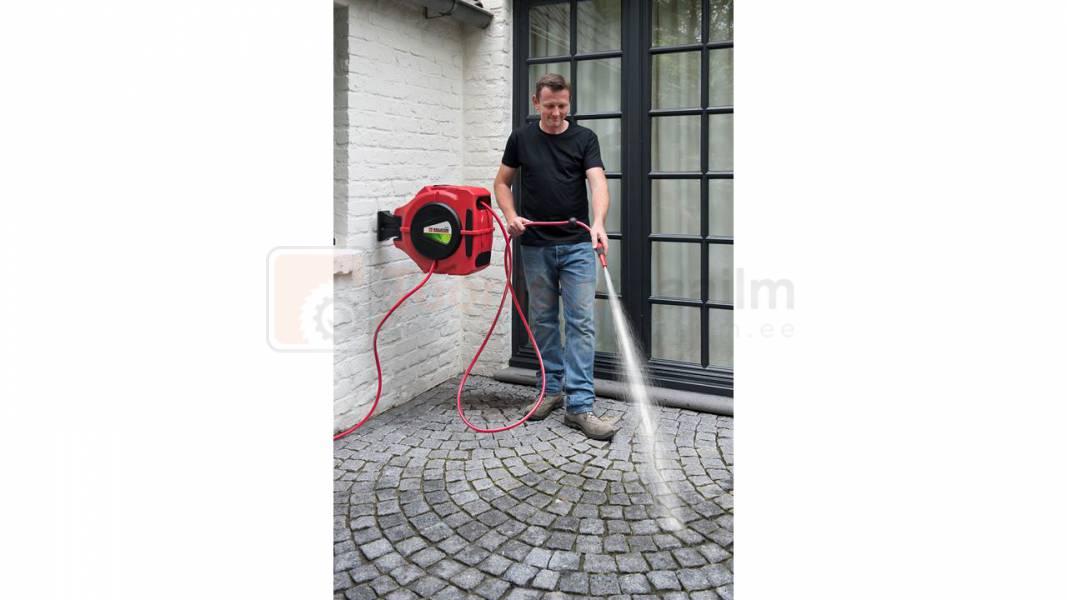 Pildil on mees, kes kasutab Kreator KRTGR6710 20-meetrist voolikupooli, et pesta väljas asuvat pinda.