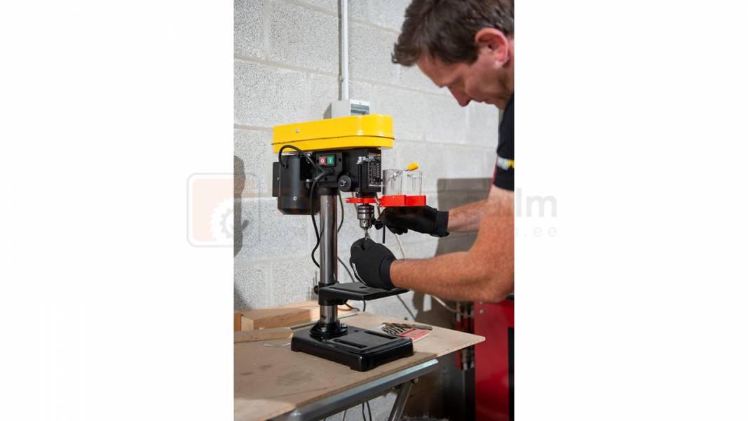 Pildil on mees, kes kasutab Powerplus X POWX153 puurpinki, et puurida materjali.