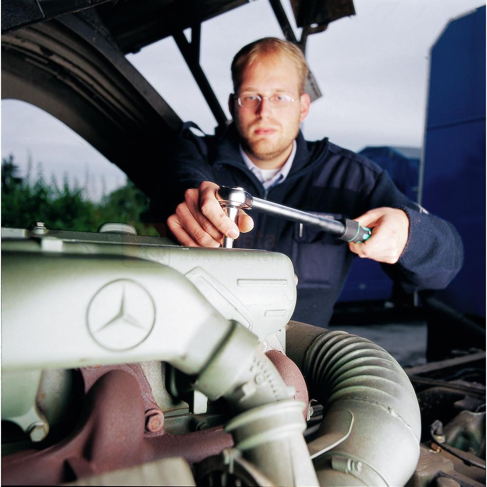 Pildil on mehaanik, kes kasutab Wera momentvõtit 3/8" 20-100 Nm, 340 mm, et parandada Mercedes-Benz mootorit.